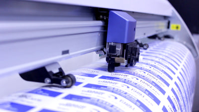 Large sheet of many small stickers being cut to easily peel away from the backing and apply to boxes