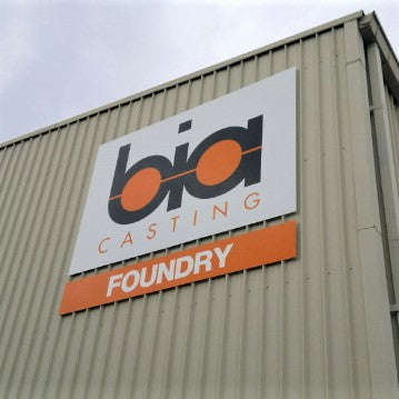 Large ACM sign with company name and logo on warehouse wall