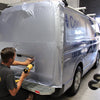 Application of a full vehicle wrap in our Port Adelaide workshop. Dureable silver vinyl and business details in large blue lettering on a fleet van