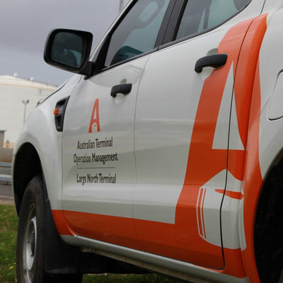 Car stickers on side panel and vehicle doors, bright orange decals for visibility