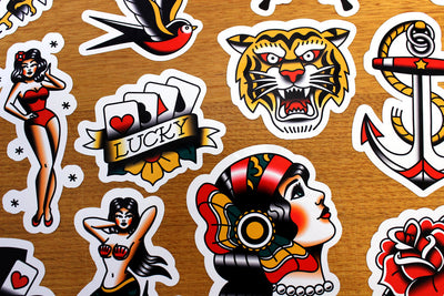 Tattoo art stickers with contoured cut outs on wooden background
